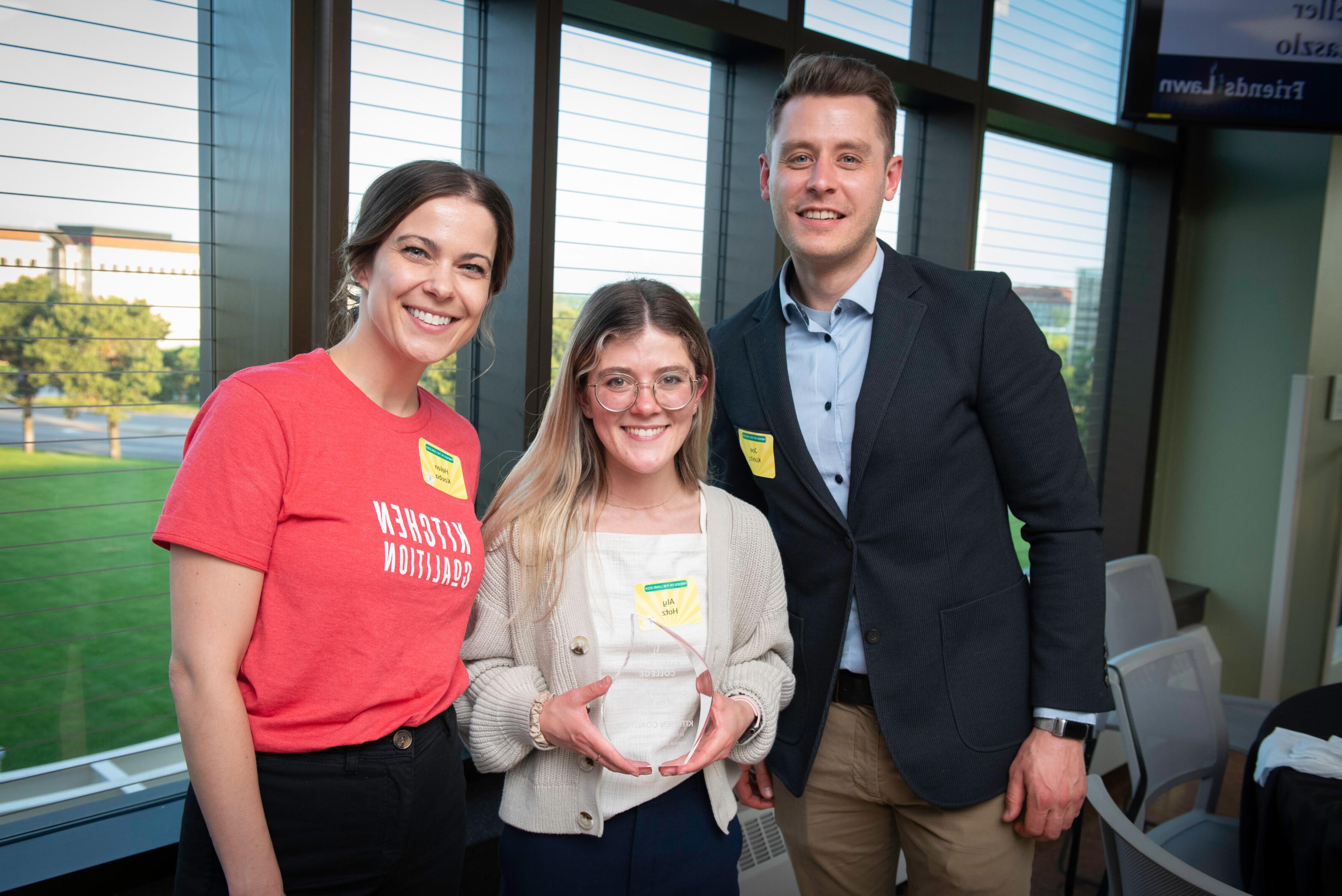 Three people accepting an award at Saint Paul College